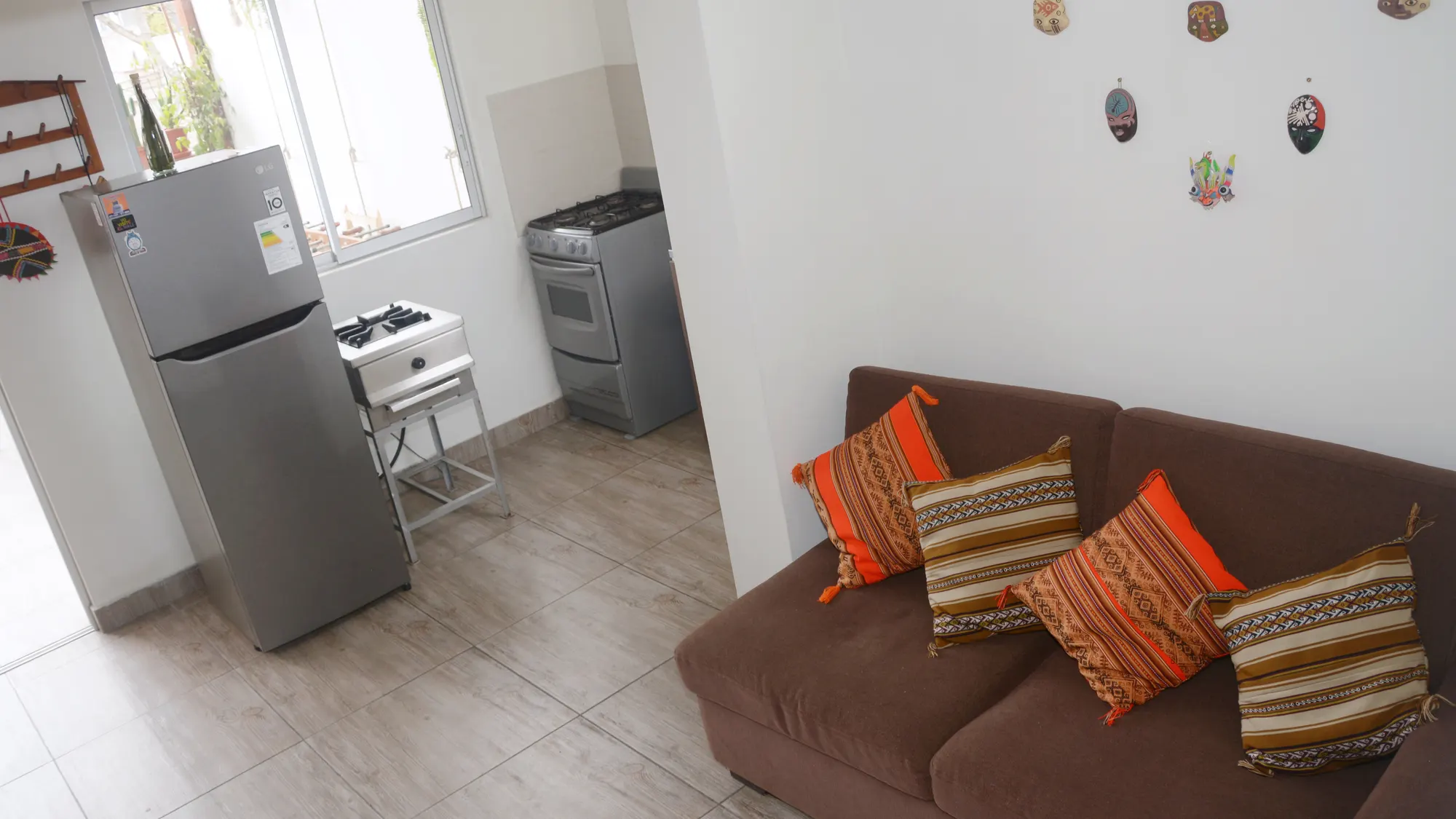 Sala del apartamento del piso 4, con sofá, refrigeradora y la cocina al fondo