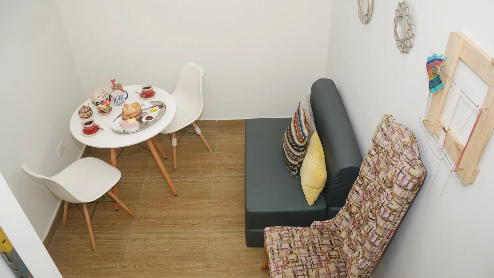 Comedor del apartamento del piso 1, con mesa redonda, sillas y banco tapizado