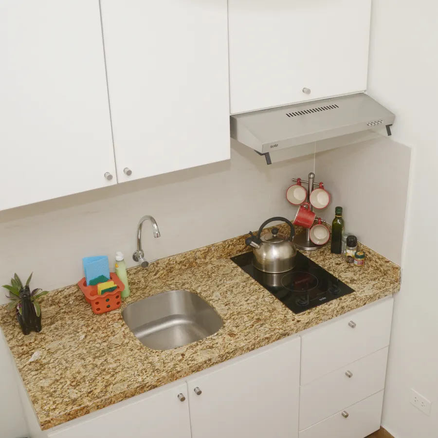 Cocina del piso 1, con encimera de granito, fregadero y campana