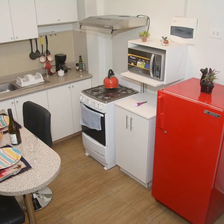 Cocina del piso 2, con horno, microondas y refrigeradora roja