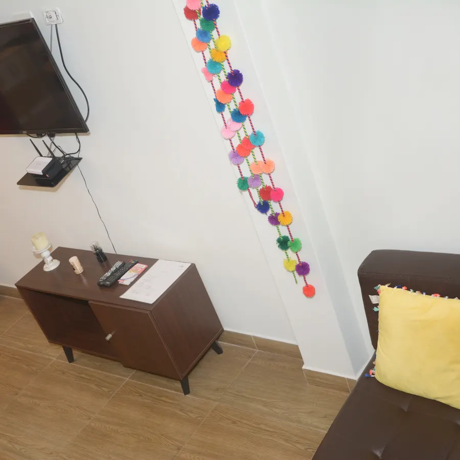 Televisor colgado en la pared del piso 2, con el sofá debajo