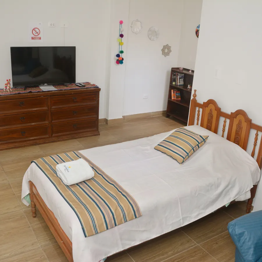 Cama del piso 3 con el televisor y la cómoda de madera enfrente