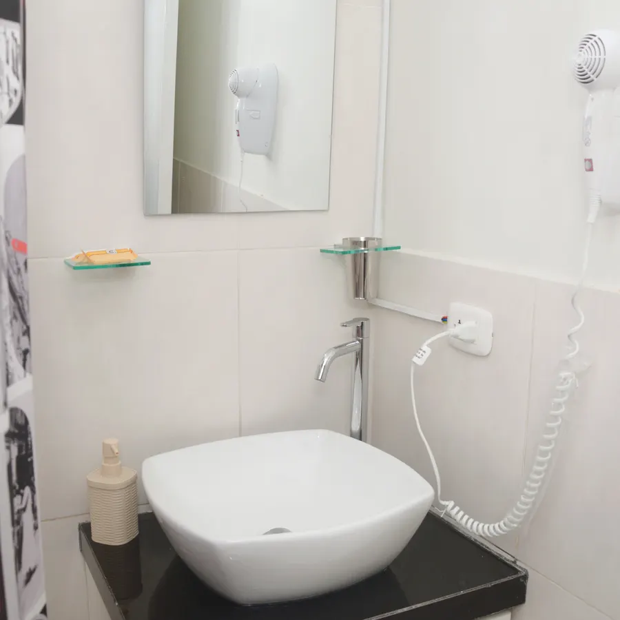 Baño del piso 3, con lavabo sobre encimera negra y espejo