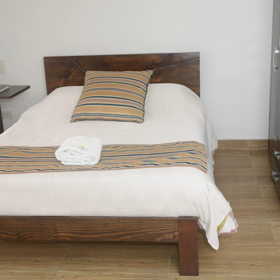 Cama doble del piso 4, con cabecero de madera oscura