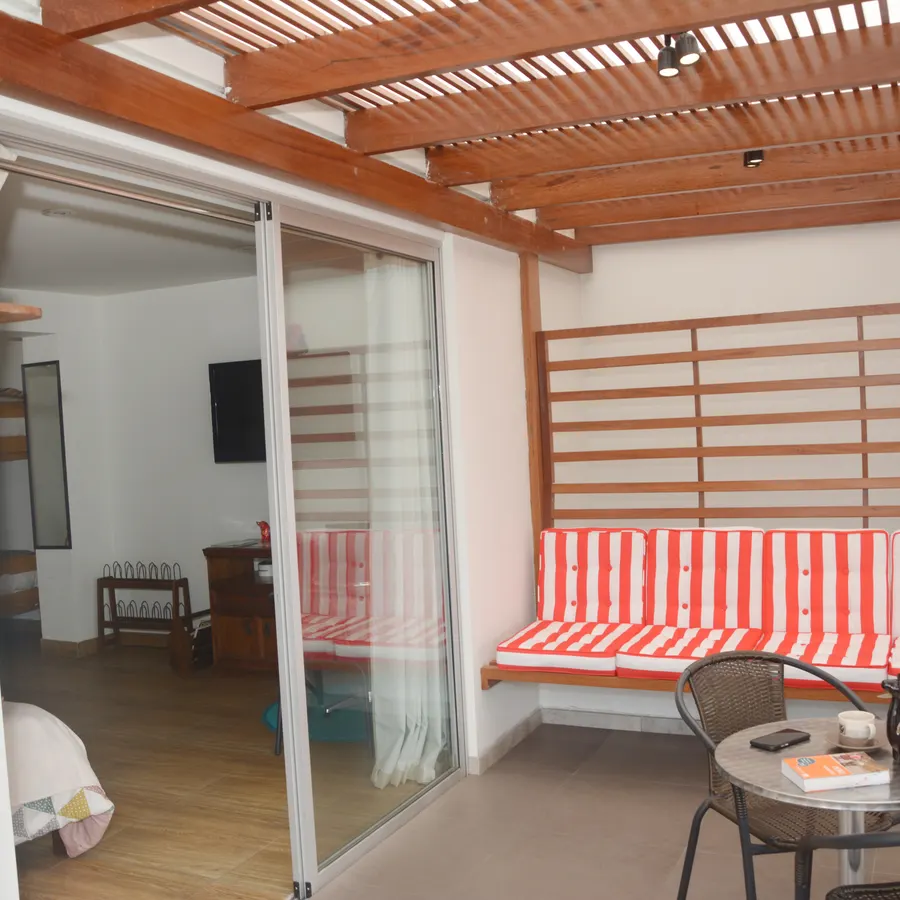 Terraza propia del piso 4, con pérgola de madera y banco a rayas